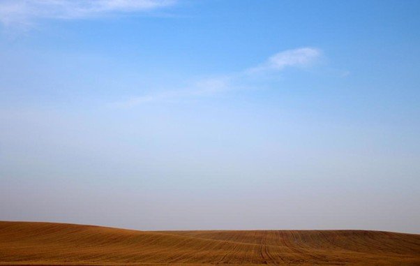 A wide, empty landscape under a pale sky