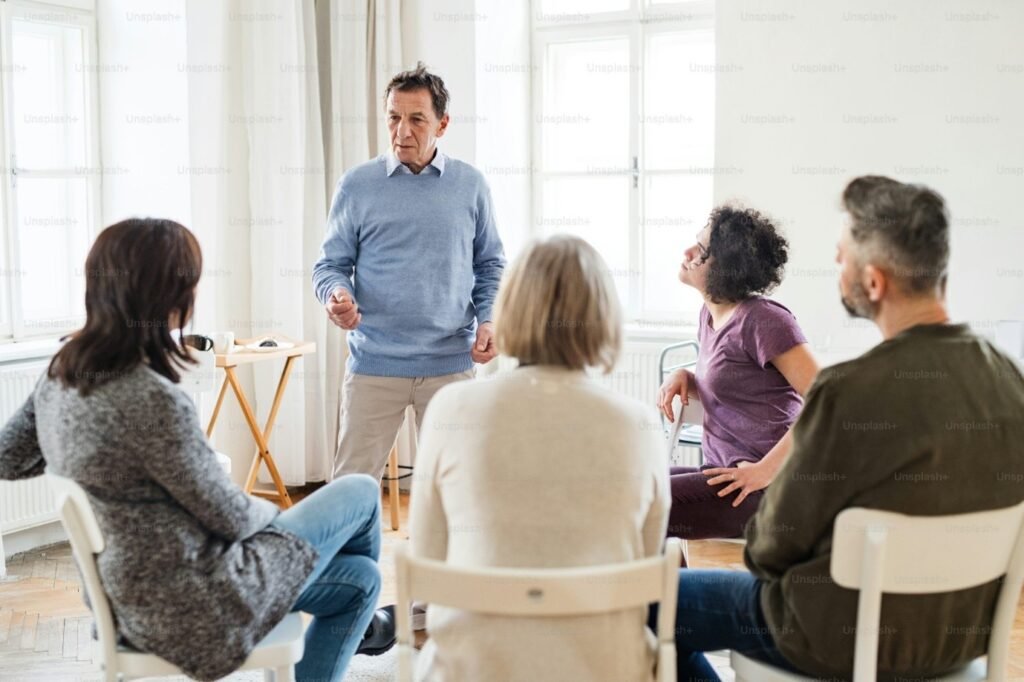 A man standing among a group, listening