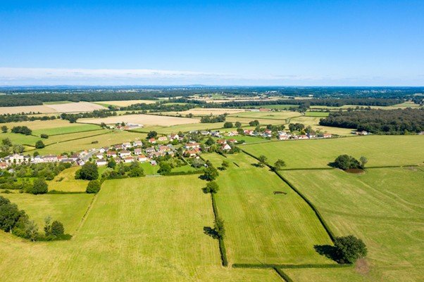 Wide grassy field under calm blue sky