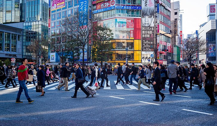 21 Watching Without Knowing Crowded city street with pedestrians walking along a busy high street during daytime.