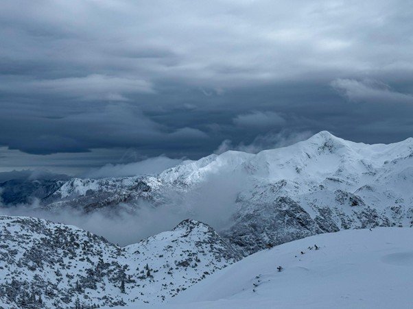 Mountain ridge beneath heavy storm clouds gathering overhead.