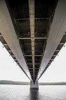 Massive steel bridge support column rising from ground.