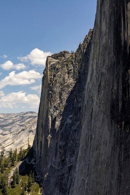 Sheer canyon wall with layered rock formations.