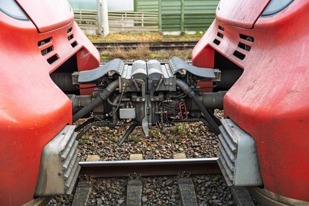 Metal coupling mechanism linking two railway cars together.
