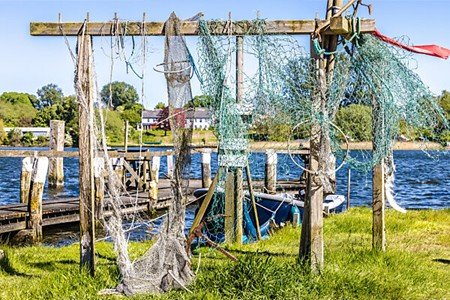Fishing nets lying beside still water