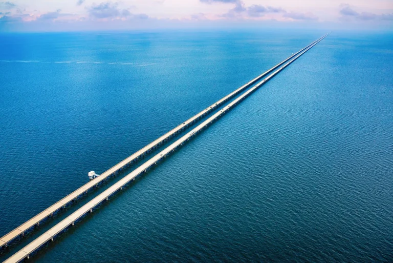 5 The Weight That Passes Through A long causeway stretching over calm coastal waters toward the horizon.