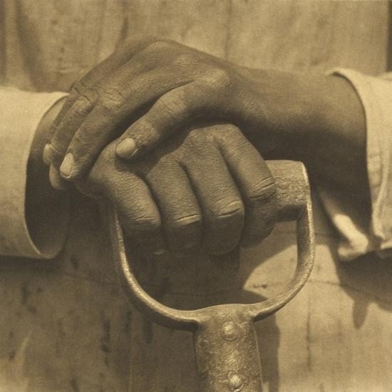 Hands resting on a worn wooden surface