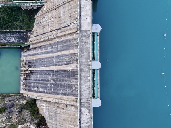 Concrete spillway channel guiding flowing water downward.