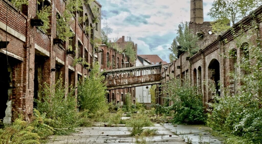 Large disused brick industrial building with empty yard.