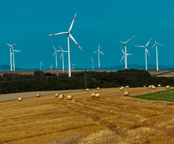 Wind turbines spaced across open hillside.
