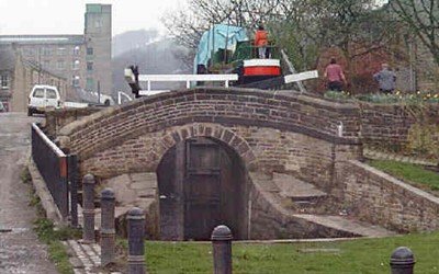 Stone canal lock chamber with wooden gates and calm water.