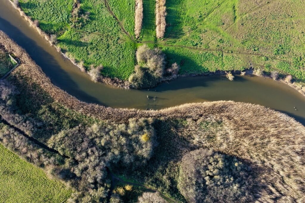 Wide river bend viewed from an elevated hillside.