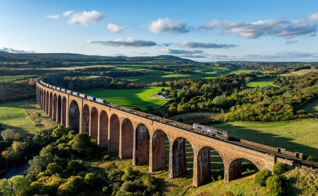 A long stone railway viaduct crossing a green valley.