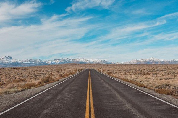 A straight road running across a wide desert landscape.