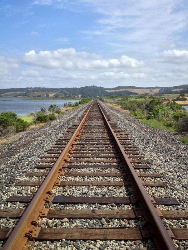 Railway tracks running straight through open countryside toward the horizon.
