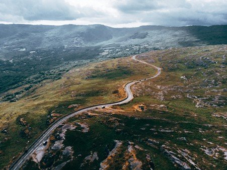 Winding mountain road passing through a steep highland valley.